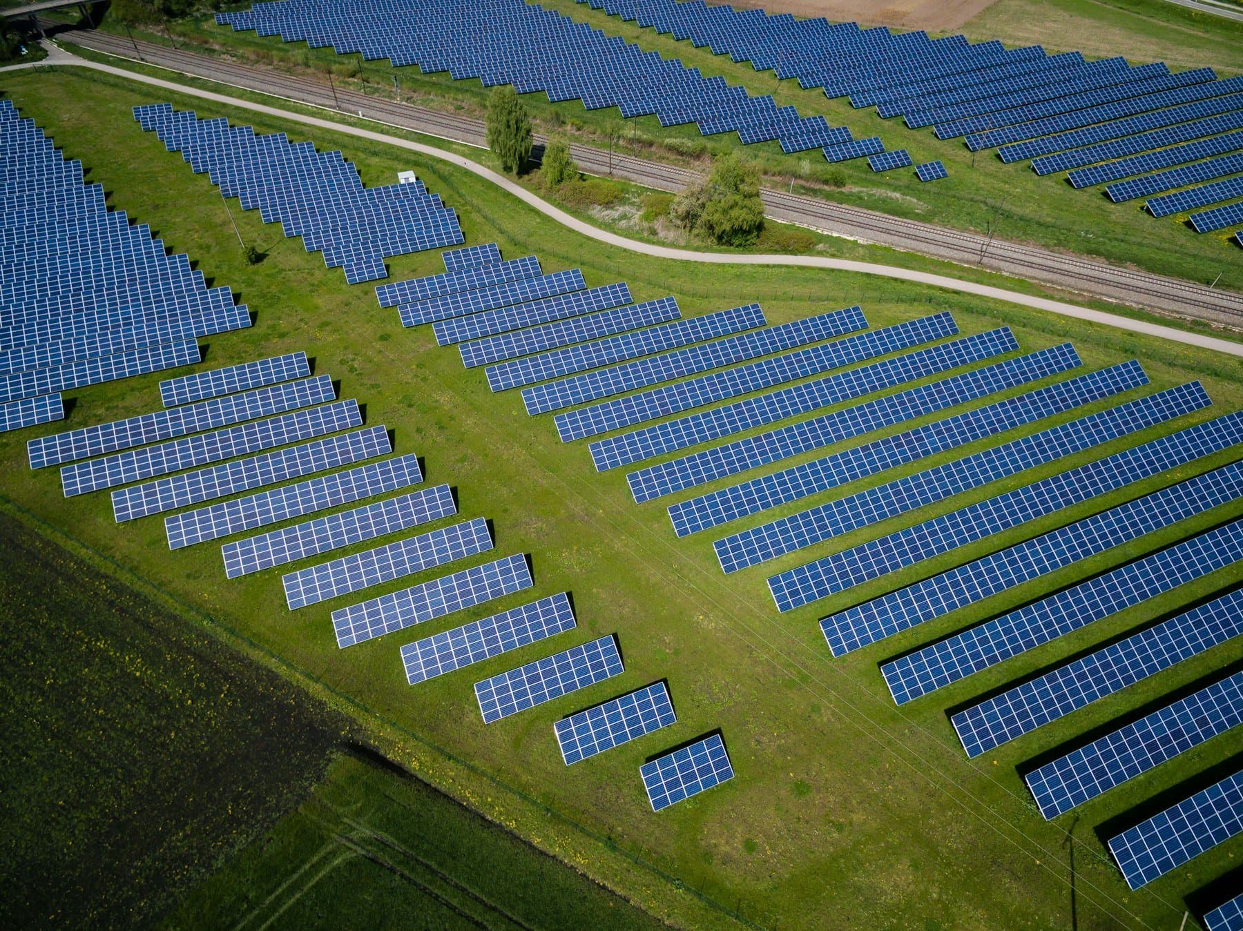 Ground-mounted solar panels across a lush green field