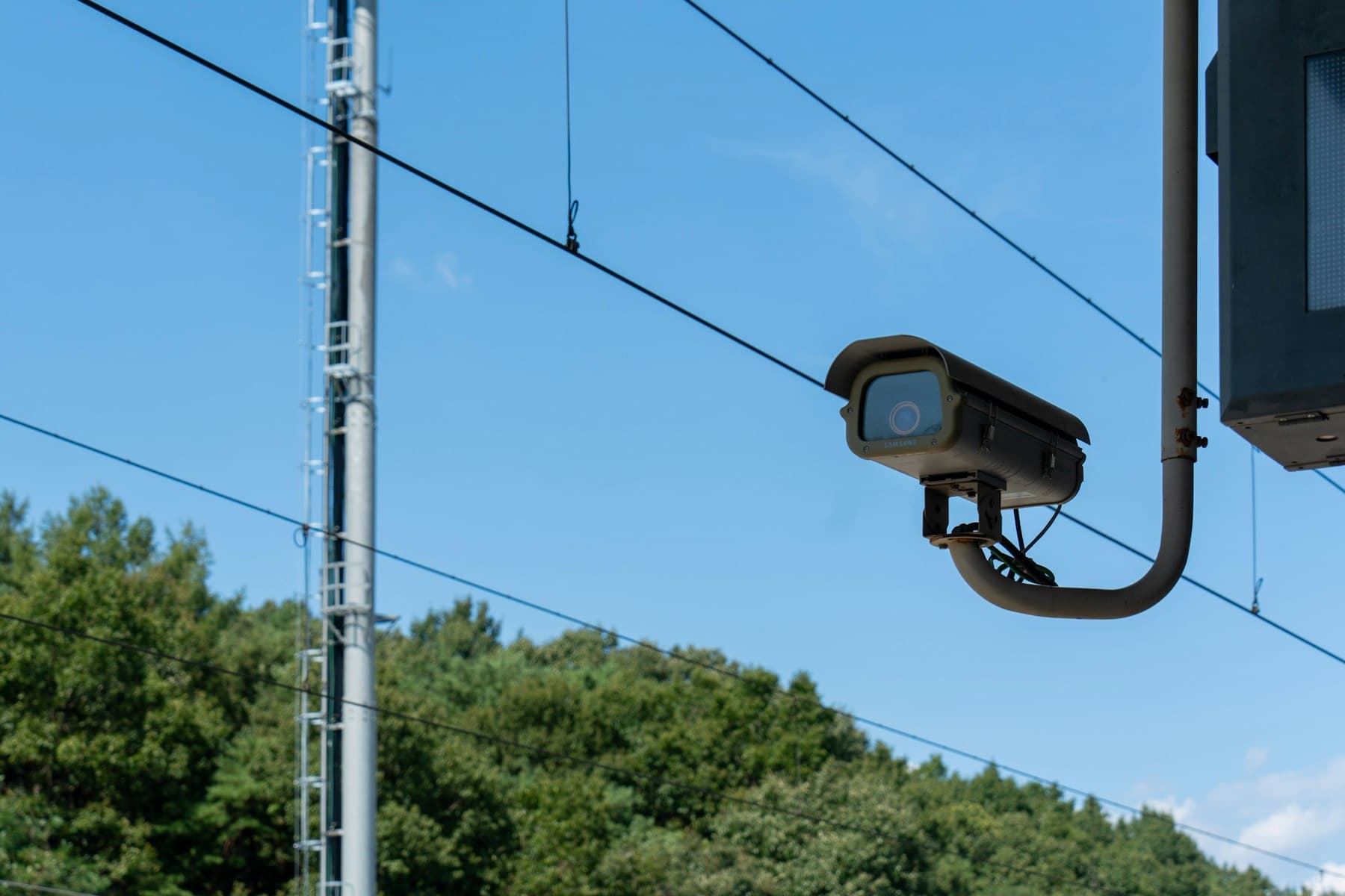 Outdoor bullet camera covering a landscaped perimeter under open sky